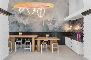 A dining room with a table and chairs and a mural on the wall